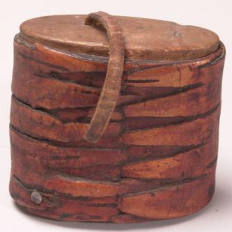 Quid box used to hold Iqmik from the Anchorage Museum of History and Art. from Goodnews Bay, early 20th century.  Walrus ivory, wood, ocher, rawhide, brass